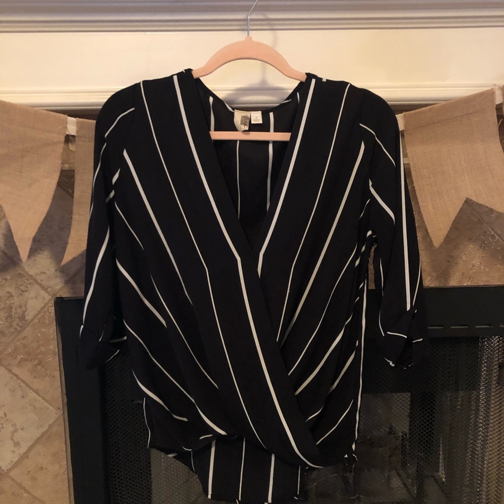 Black and white wrap blouse with cuffed sleeves.